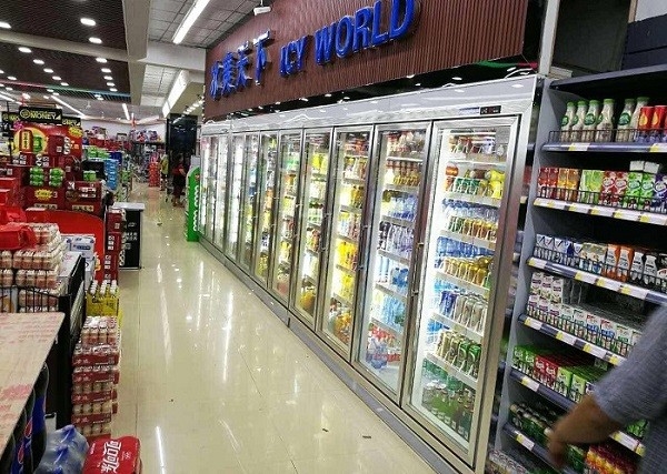 Cella frigorifera dell'esposizione della bevanda fresca del supermercato, passeggiata commerciale nella stanza del congelatore